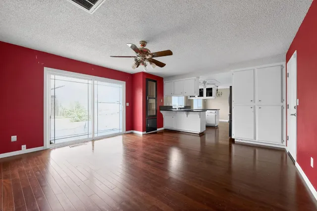 a view of a livingroom with furniture a ceiling fan and wooden floor