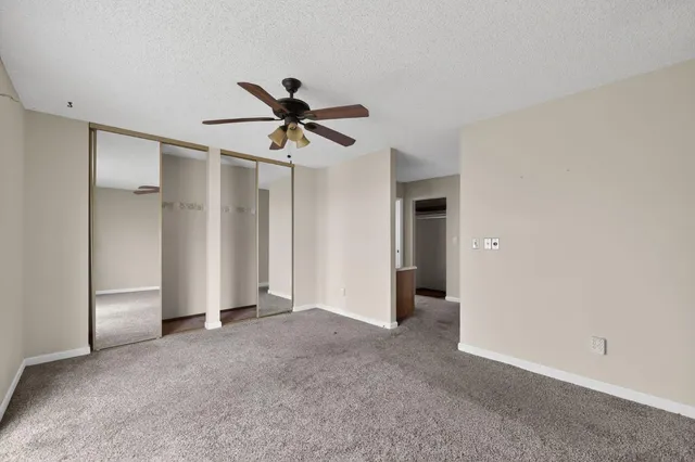 a view of a big room with closet and a ceiling fan