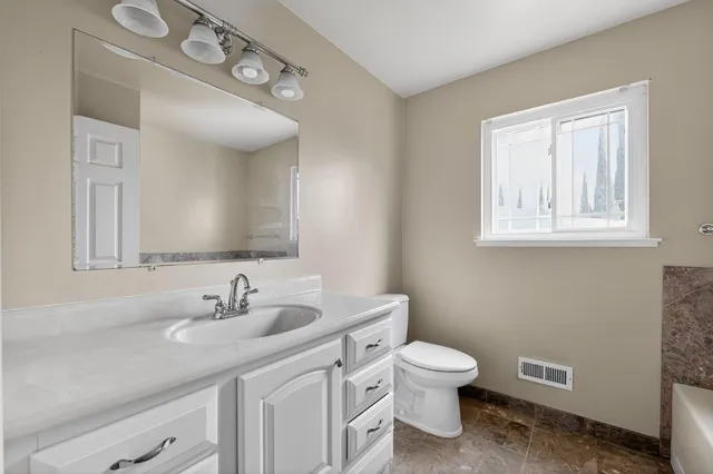 a bathroom with a toilet a sink and mirror