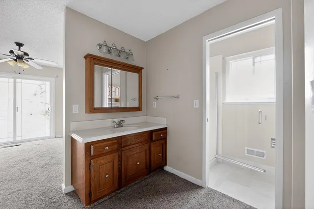 a bathroom with a granite countertop sink and a mirror
