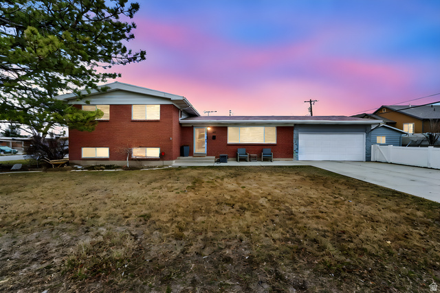 487 East 9270th Street South Sandy, UT 84070 - Photo 1 of 1 Split level home with brick siding, an attached garage, concrete driveway, and a patio area