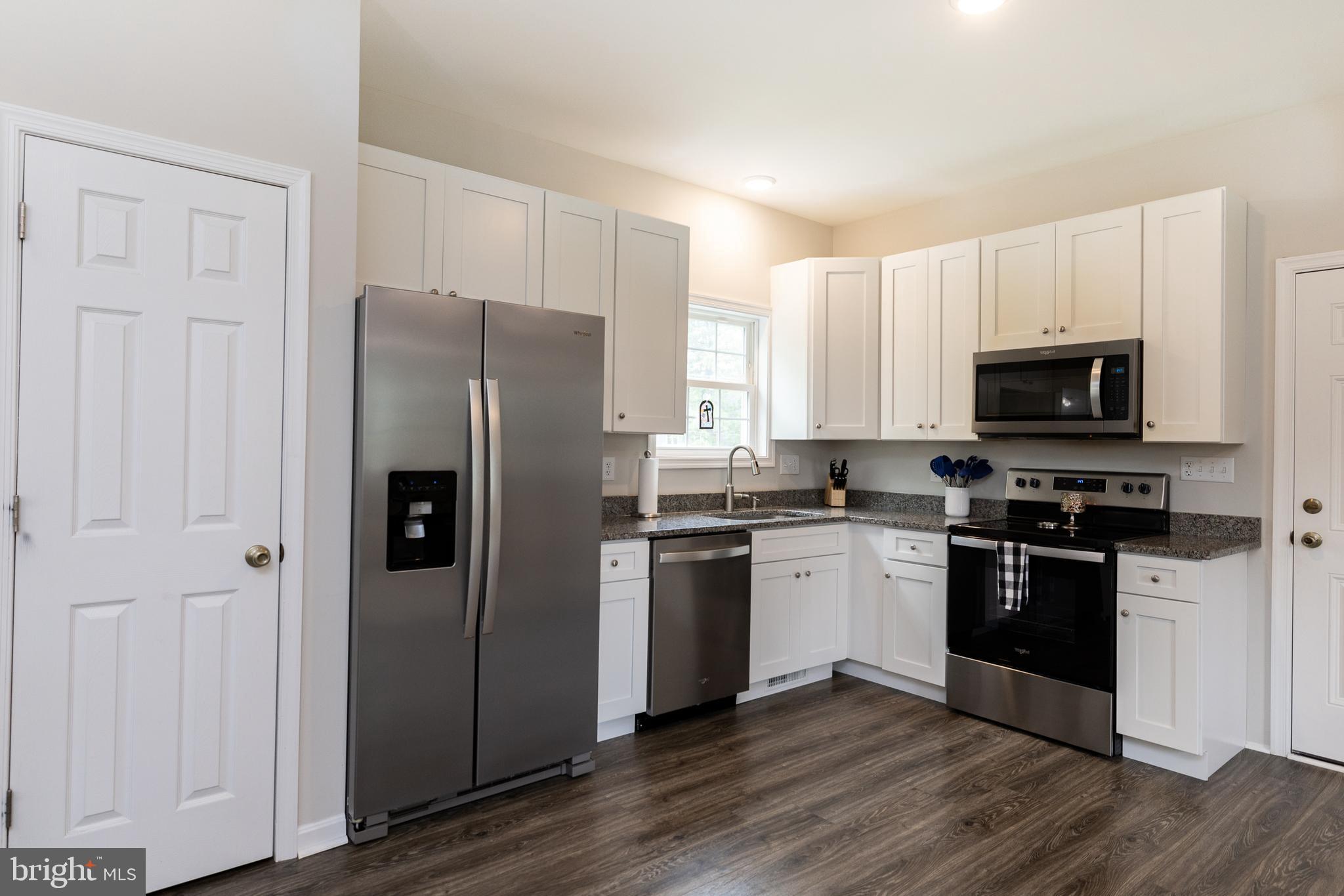 33 Sinker Drive Inwood, WV 25428 - Photo 12 of 31 a kitchen with a refrigerator stove and wooden cabinets
