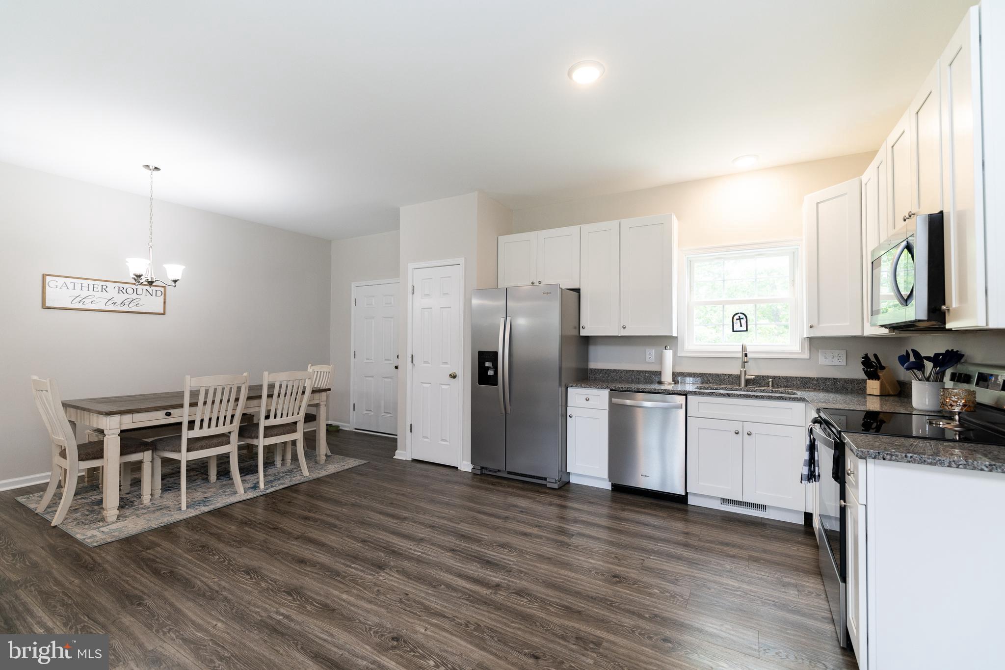 33 Sinker Drive Inwood, WV 25428 - Photo 9 of 31 a kitchen with stainless steel appliances wooden floors and white cabinets