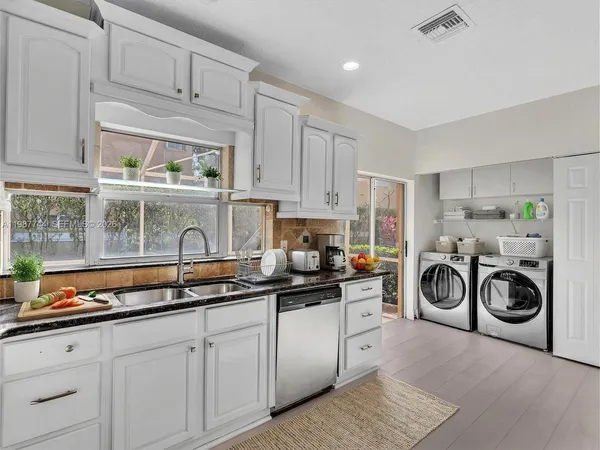 a kitchen with granite countertop white cabinets and white appliances