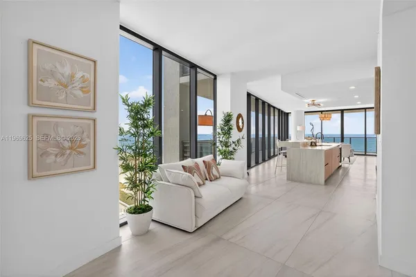 a living room with furniture a flat screen tv and a large window