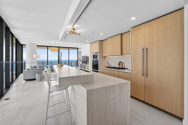 a living room with furniture large window and wooden floor