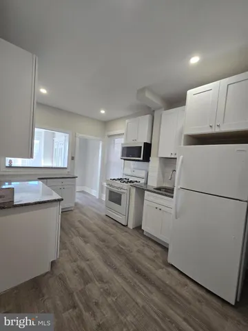 a kitchen with white cabinets and white appliances
