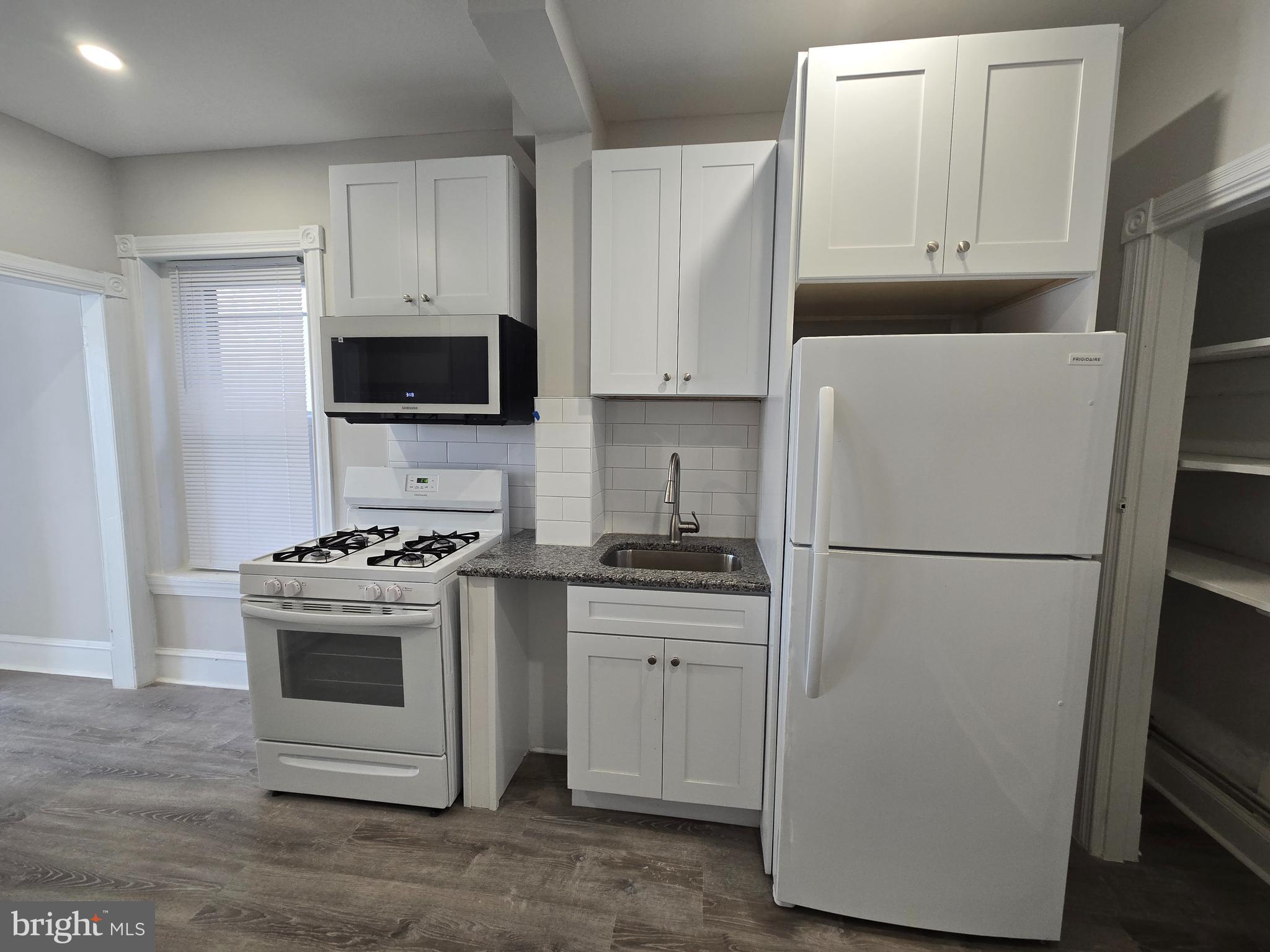 5211 Ridge Avenue, Unit 2 Philadelphia, PA 19128 - Photo 3 of 23 a white refrigerator freezer and a stove sitting inside of a kitchen with granite countertop a refrigerator