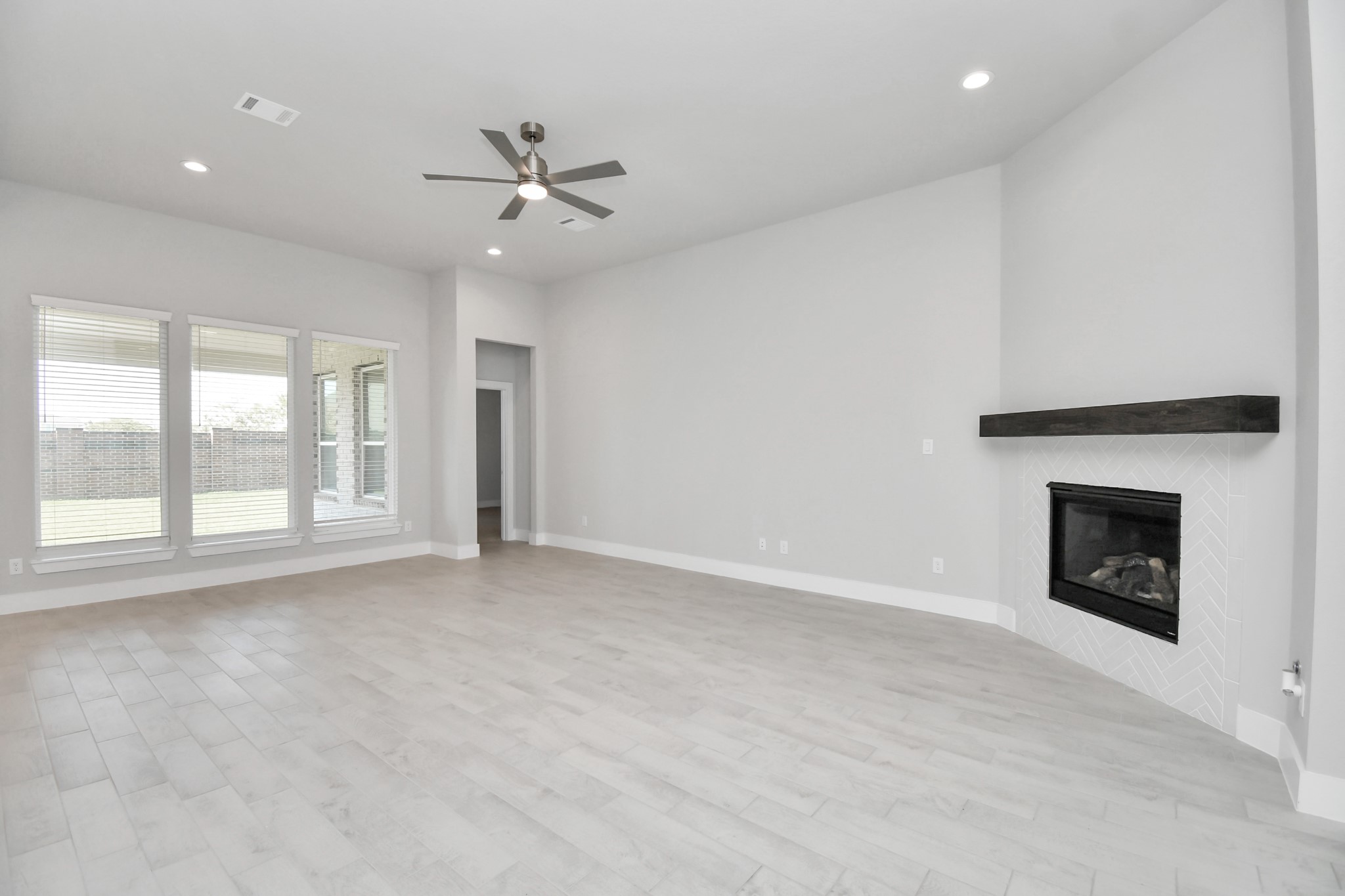 3031 Native Spg Drive Spring, TX 77373 - Photo 13 of 30 Family room flooded with natural light through the expansive windows. The premium tile flooring adds a touch of luxury to the space, creating the perfect setting for relaxing moments and cherished gatherings with loved ones. Sample photo of completed home with similar floor plan. Actual colors and selections may vary.