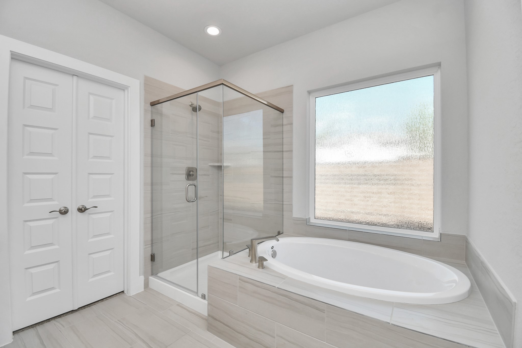 3031 Native Spg Drive Spring, TX 77373 - Photo 19 of 30 Indulge in a spa-like retreat within the confines of this primary bathroom. Delight in a spacious walk-in shower enveloped in stylish tile surround and unwind in a separate garden tub adorned with custom detailing. Sample photo of completed home with similar floor plan. Actual colors and selections may vary.
