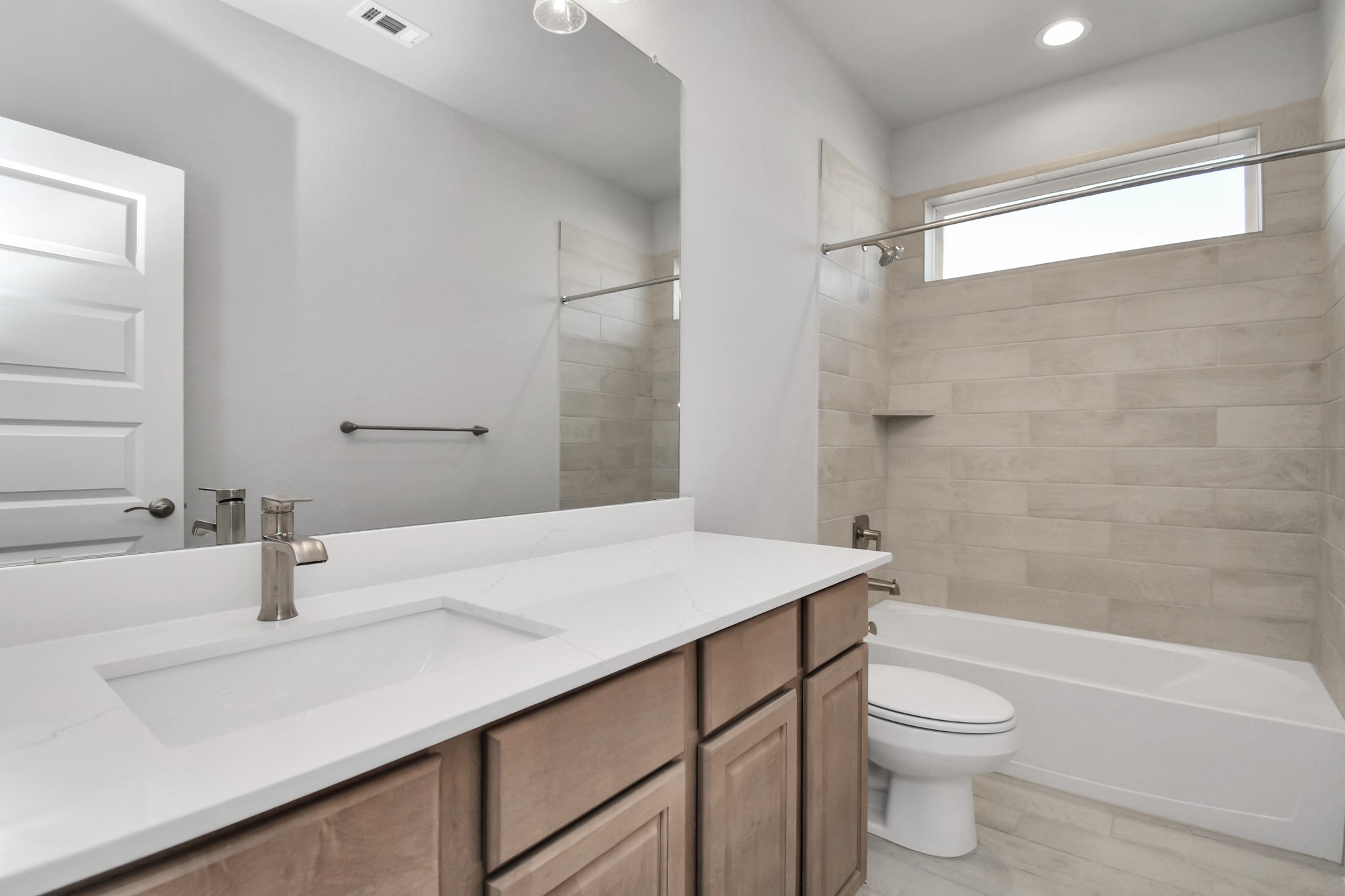 3031 Native Spg Drive Spring, TX 77373 - Photo 26 of 30 Secondary bath features tile flooring, bath/shower combo with tile surround, light stained wood cabinets, beautiful light countertop. Sample photo of completed home with similar floor plan. Actual colors and selections may vary.
