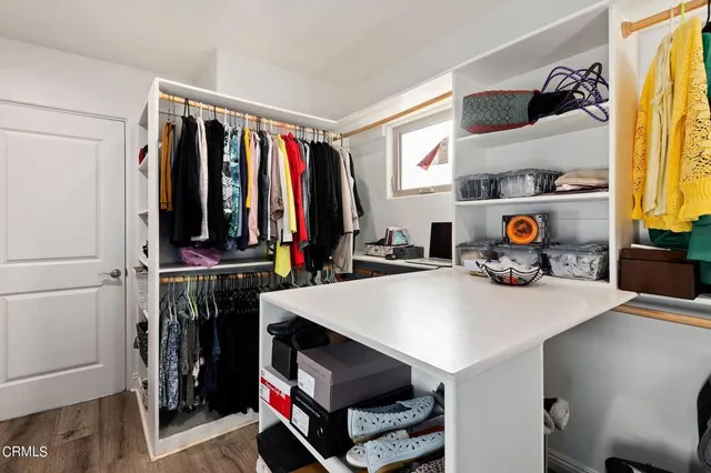 a view of walk in closet with clothes and shoes