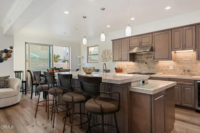 a kitchen with a dining table chairs sink and cabinets