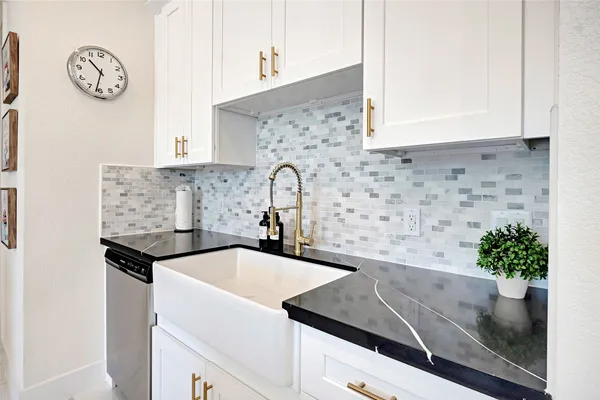 a kitchen with granite countertop a sink and a stove