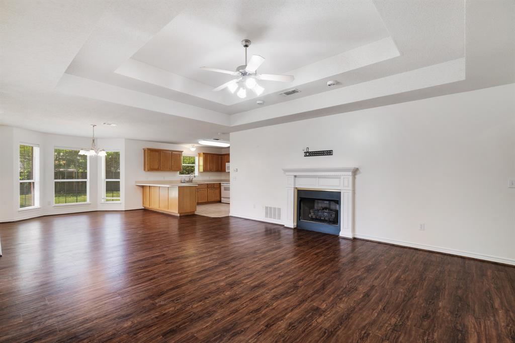 3750 Castlegate Drive Paris, TX 75462 - Photo 5 of 20 a view of an empty room with wooden floor fireplace and a window