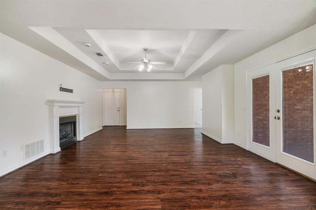 3750 Castlegate Drive Paris, TX 75462 - Photo 6 of 20 an empty room with wooden floor fireplace and windows