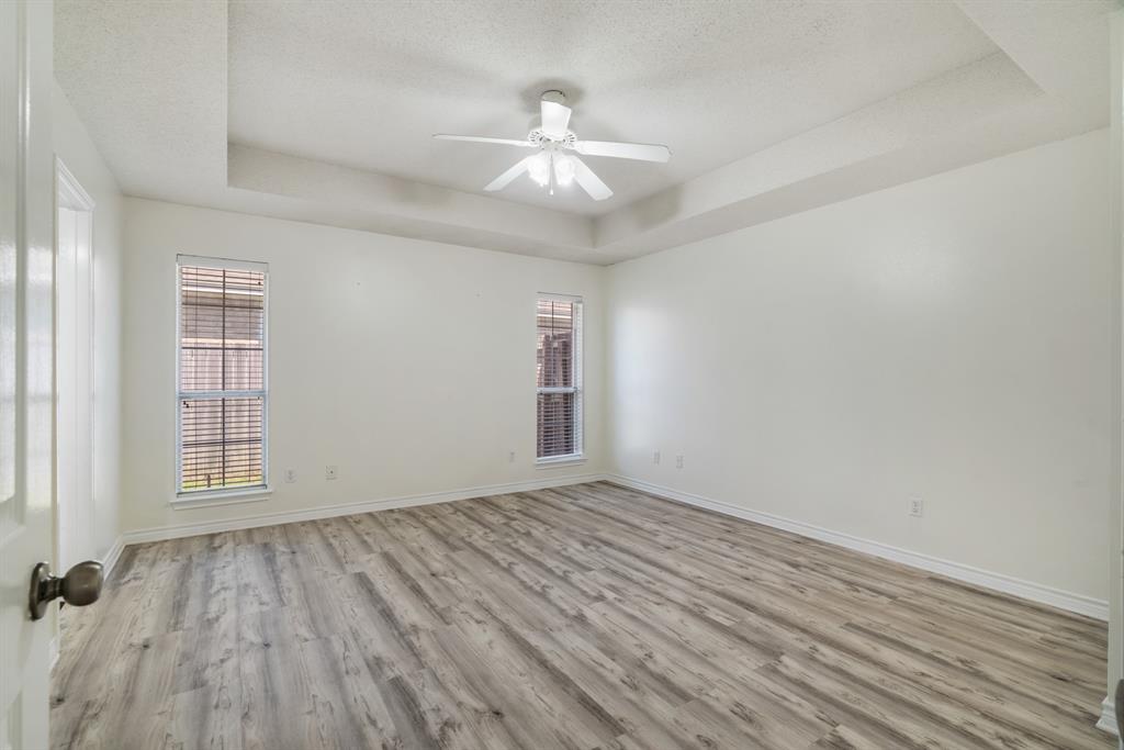 3750 Castlegate Drive Paris, TX 75462 - Photo 10 of 20 an empty room with wooden floor chandelier fan and windows