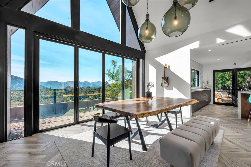 24301 Sylvan Glen Road Calabasas, CA 91302 - Photo 20 of 64 a dining room with furniture a large window and a chandelier