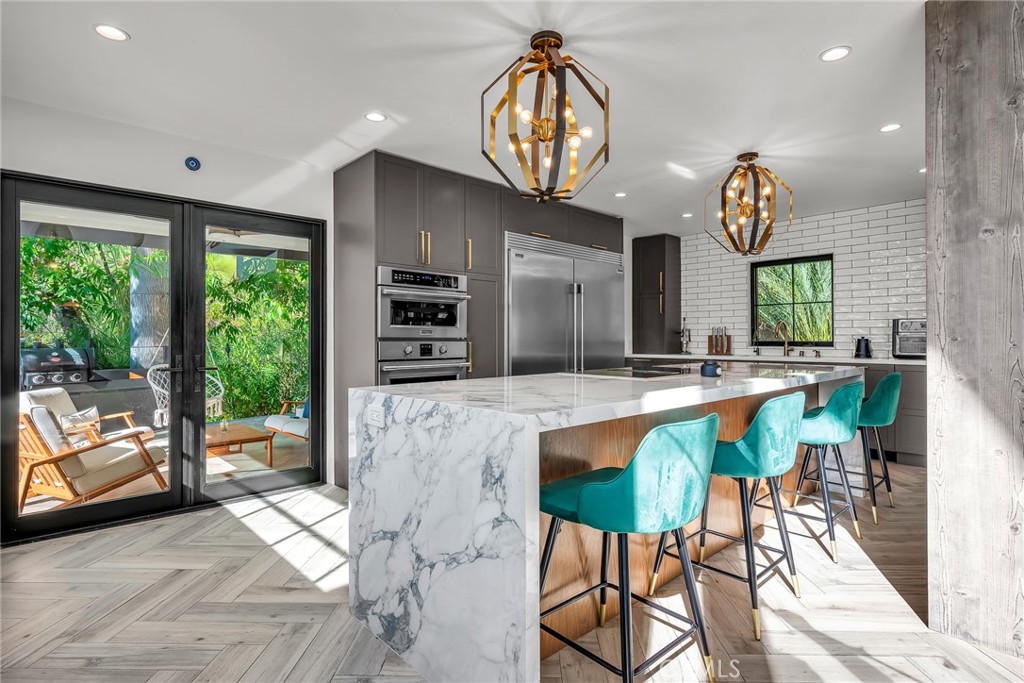 24301 Sylvan Glen Road Calabasas, CA 91302 - Photo 24 of 64 a view of a dining room with furniture a chandelier and wooden floor