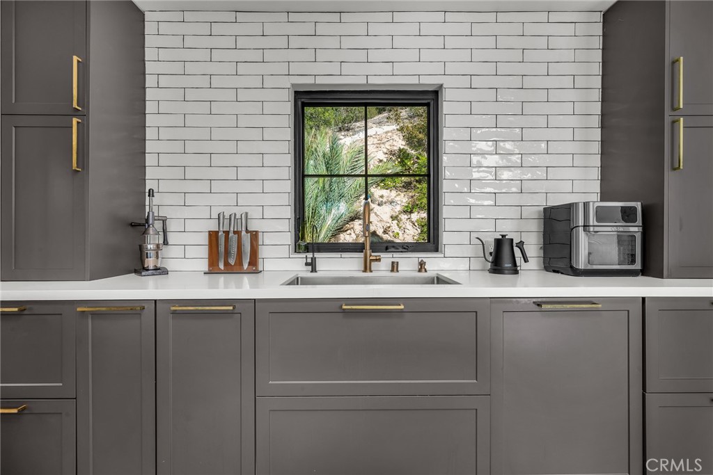 24301 Sylvan Glen Road Calabasas, CA 91302 - Photo 27 of 64 a kitchen with stainless steel appliances a sink and a window