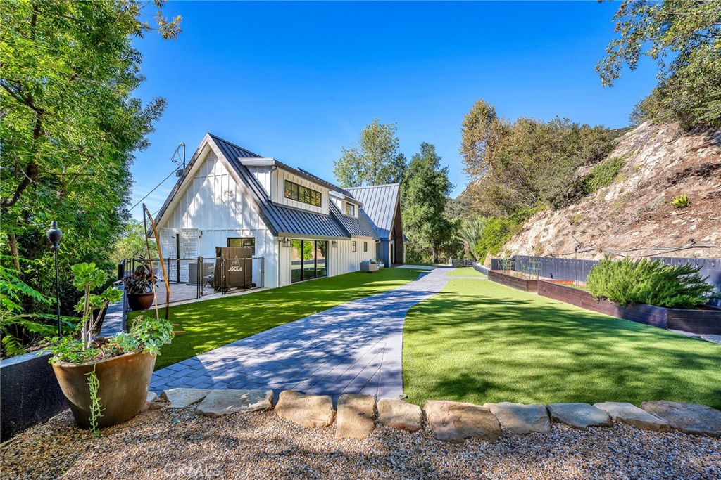 24301 Sylvan Glen Road Calabasas, CA 91302 - Photo 3 of 64 a front view of a house with a yard