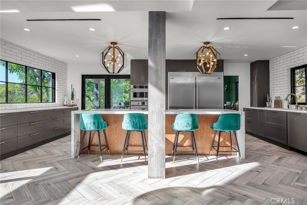 24301 Sylvan Glen Road Calabasas, CA 91302 - Photo 31 of 64 a view of a kitchen with a fireplace and large windows
