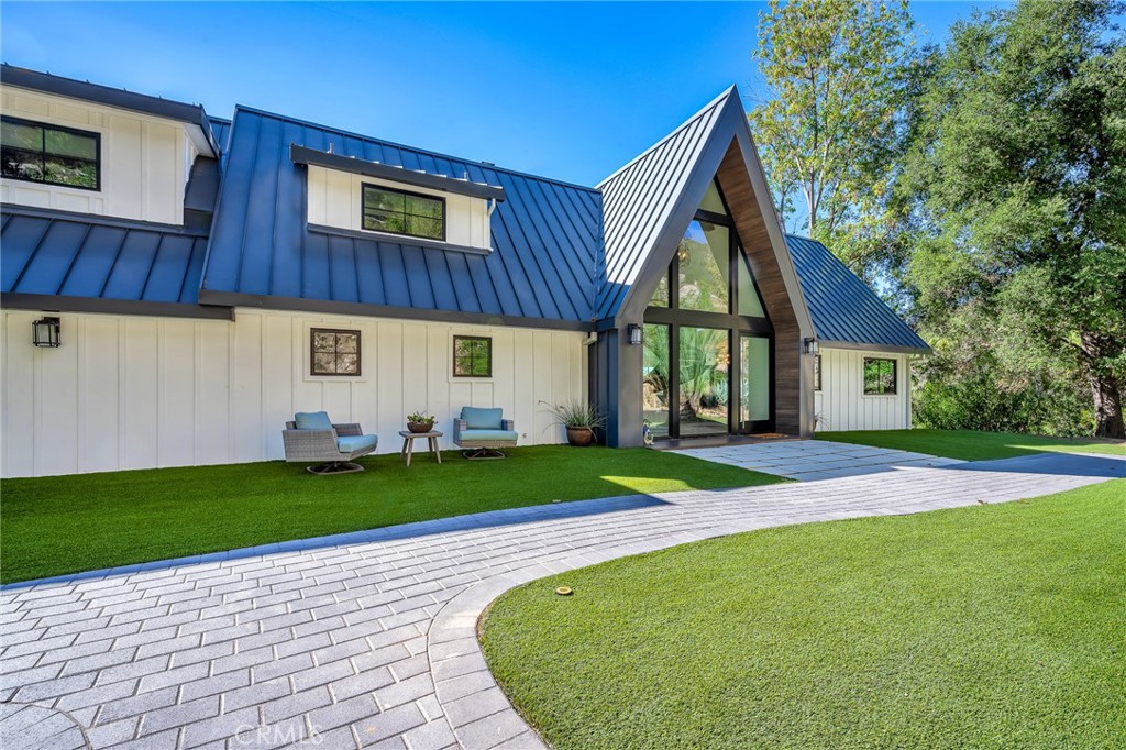 24301 Sylvan Glen Road Calabasas, CA 91302 - Photo 5 of 64 a front view of a house with a yard and garage