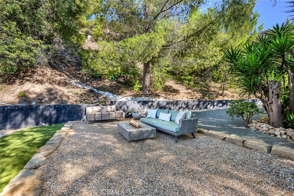 24301 Sylvan Glen Road Calabasas, CA 91302 - Photo 52 of 64 a view of a backyard with lawn chairs and a fire pit