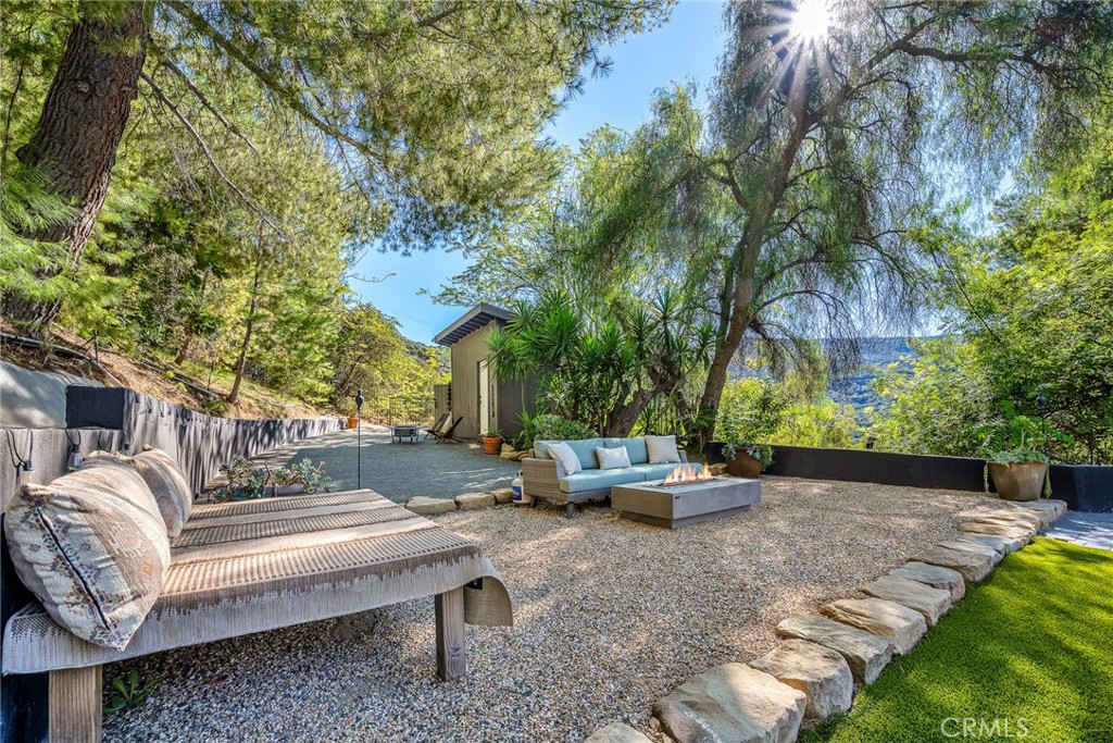 24301 Sylvan Glen Road Calabasas, CA 91302 - Photo 53 of 64 a view of a patio with couches and chairs under an umbrella