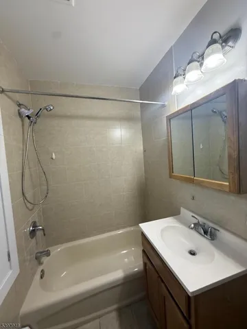 a bathroom with a sink vanity tub and shower