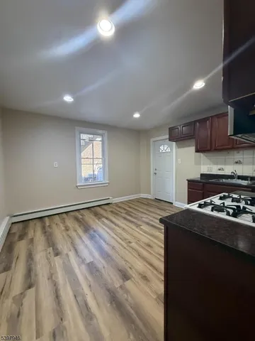 a kitchen with kitchen island granite countertop a sink stove and cabinets