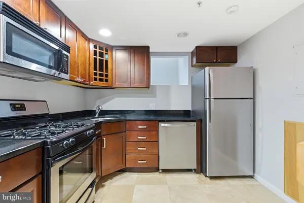 a kitchen with stainless steel appliances granite countertop a sink stove and microwave