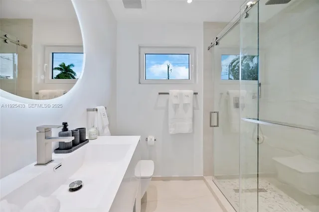 a bathroom with a sink a toilet and shower