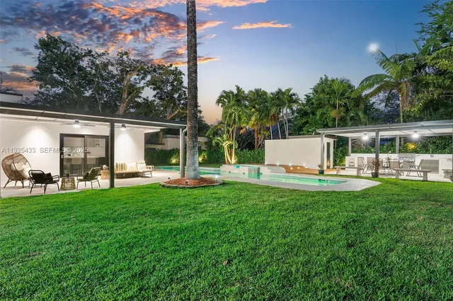 a view of a house with backyard and sitting area