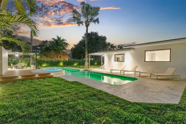 a view of a house with pool and a yard