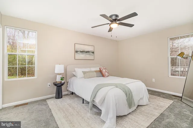 a bedroom with a bed and a large window