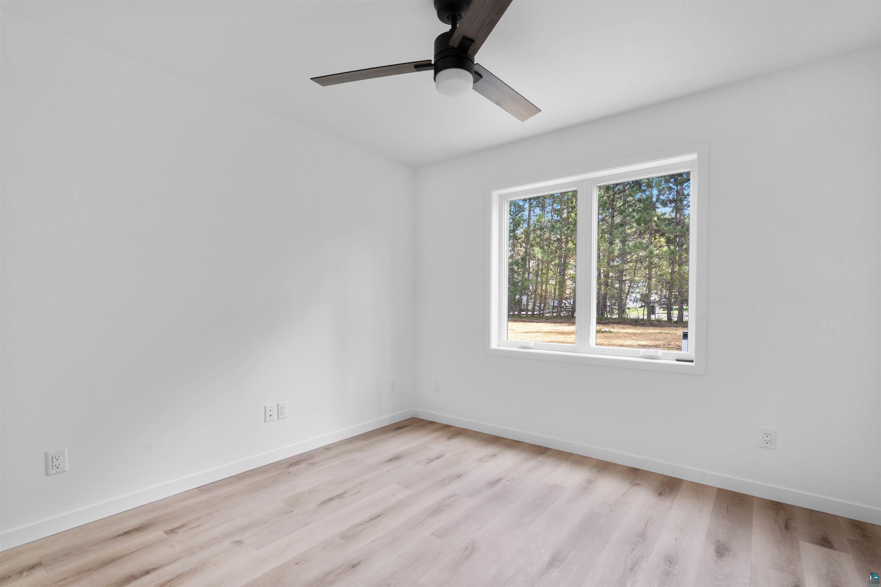1386 Stephen Road Cloquet, MN 55720 - Photo 23 of 25 Bright interior space featuring a large window, light wood-finish flooring, white baseboards, and a contemporary ceiling fan