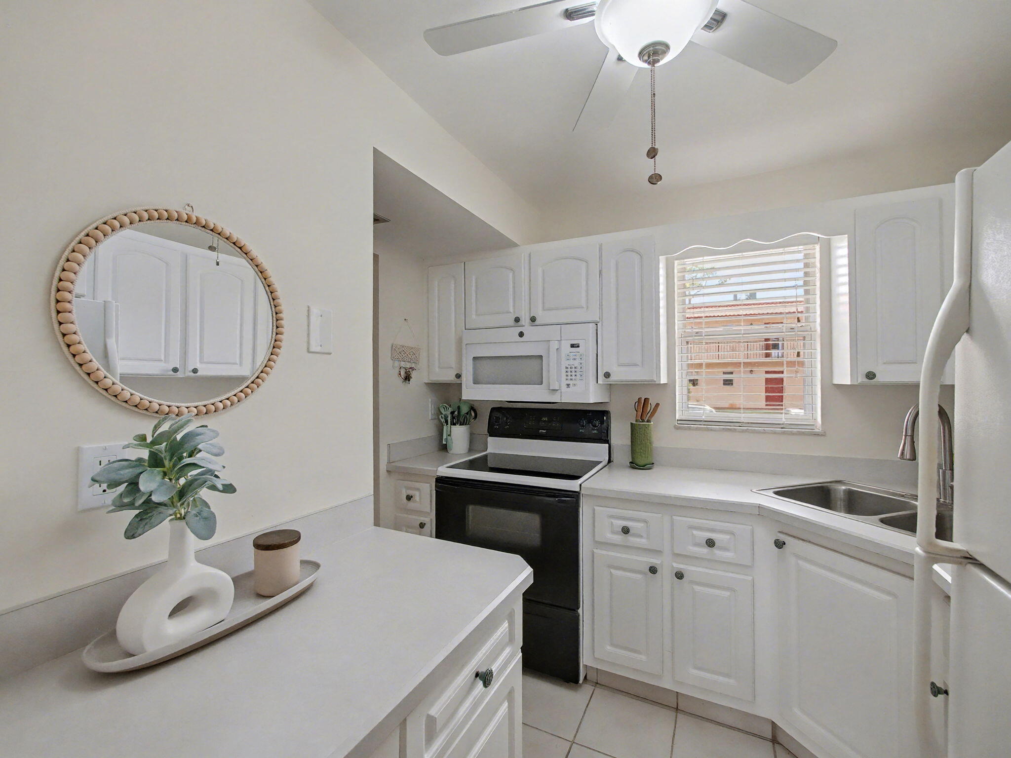 1967 Southwest Palm City Road, Unit 34C Stuart, FL 34994 - Photo 5 of 25 a kitchen with cabinets a sink and a stove