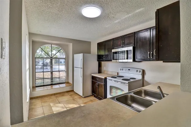 a kitchen with stainless steel appliances granite countertop a refrigerator and a stove top oven