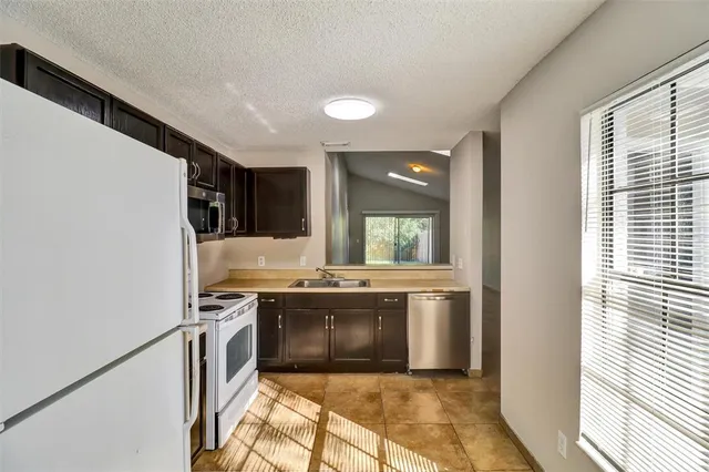 a kitchen with a sink stove and refrigerator