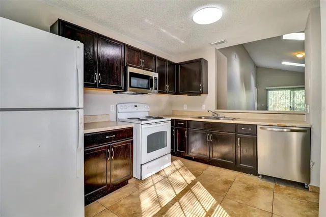 a kitchen with a stove top oven and refrigerator