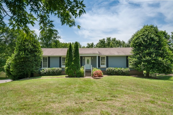 a front view of house with yard and green space