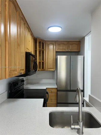 a kitchen with stainless steel appliances granite countertop a refrigerator and a sink