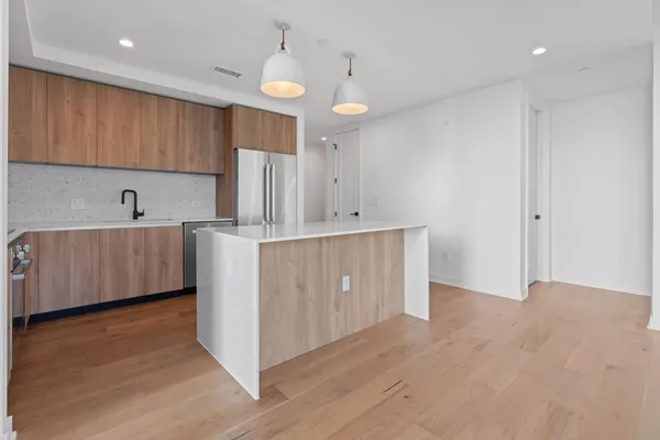 a kitchen with granite countertop a refrigerator and a sink