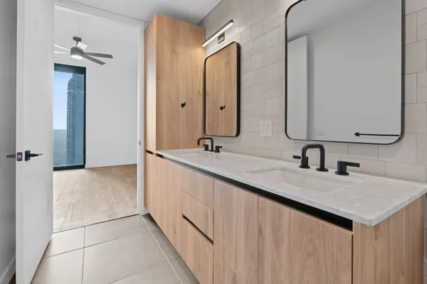 a bathroom with a granite countertop sink a mirror and shower
