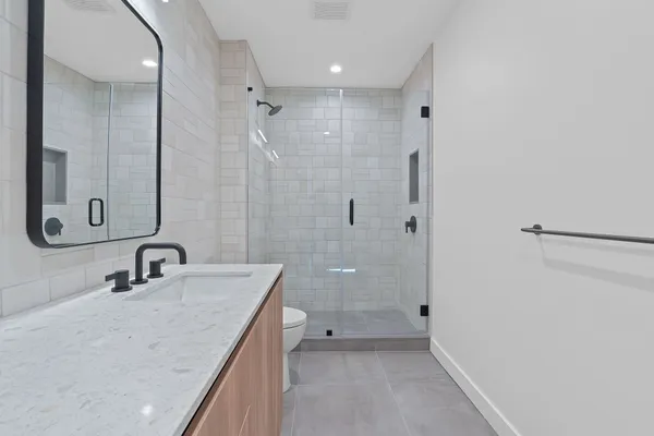 a bathroom with a sink a toilet and shower