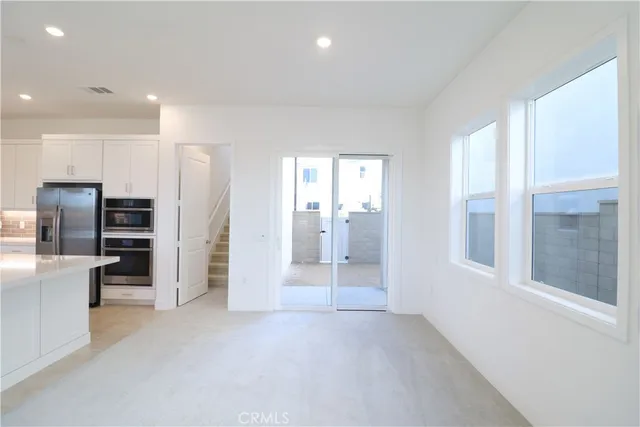 a view of a kitchen with refrigerator and window