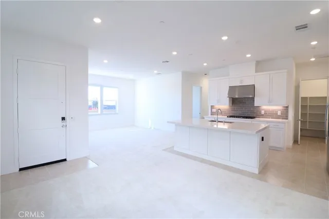 a view of kitchen with kitchen island stainless steel appliances wooden cabinets and window