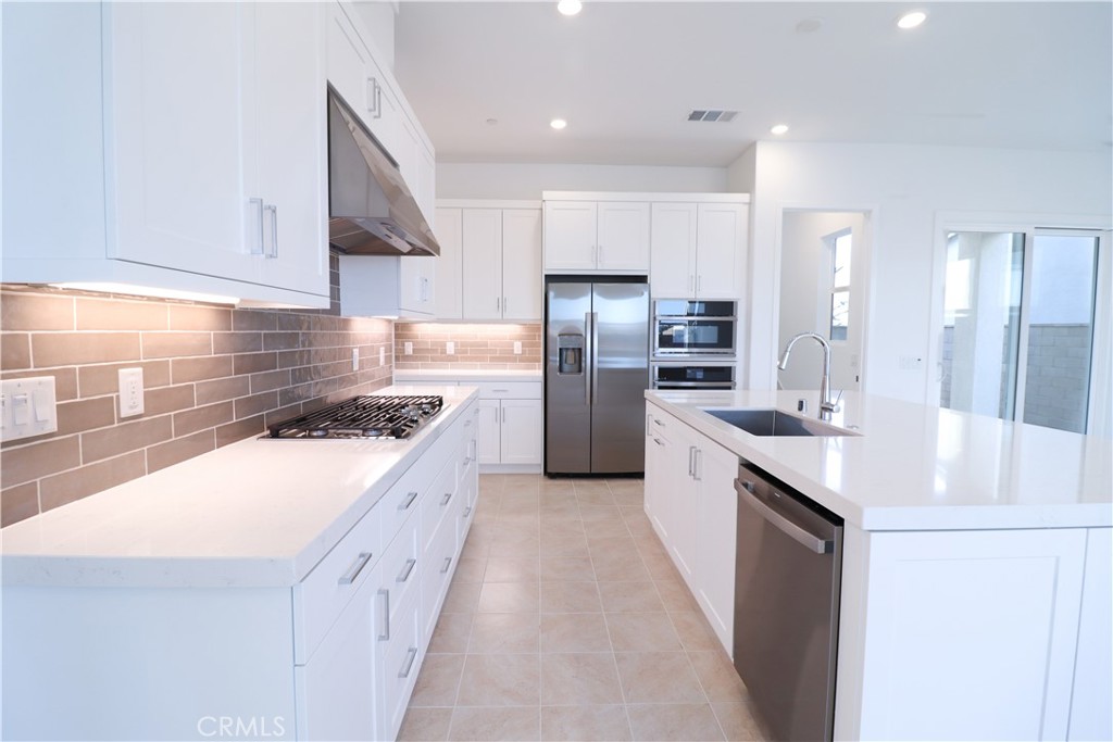 647 Gadwall Irvine, CA 92618 - Photo 7 of 29 a kitchen with stainless steel appliances granite countertop a sink stove and refrigerator