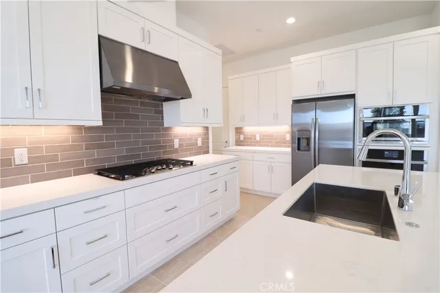 a kitchen with granite countertop a sink stainless steel appliances and cabinets